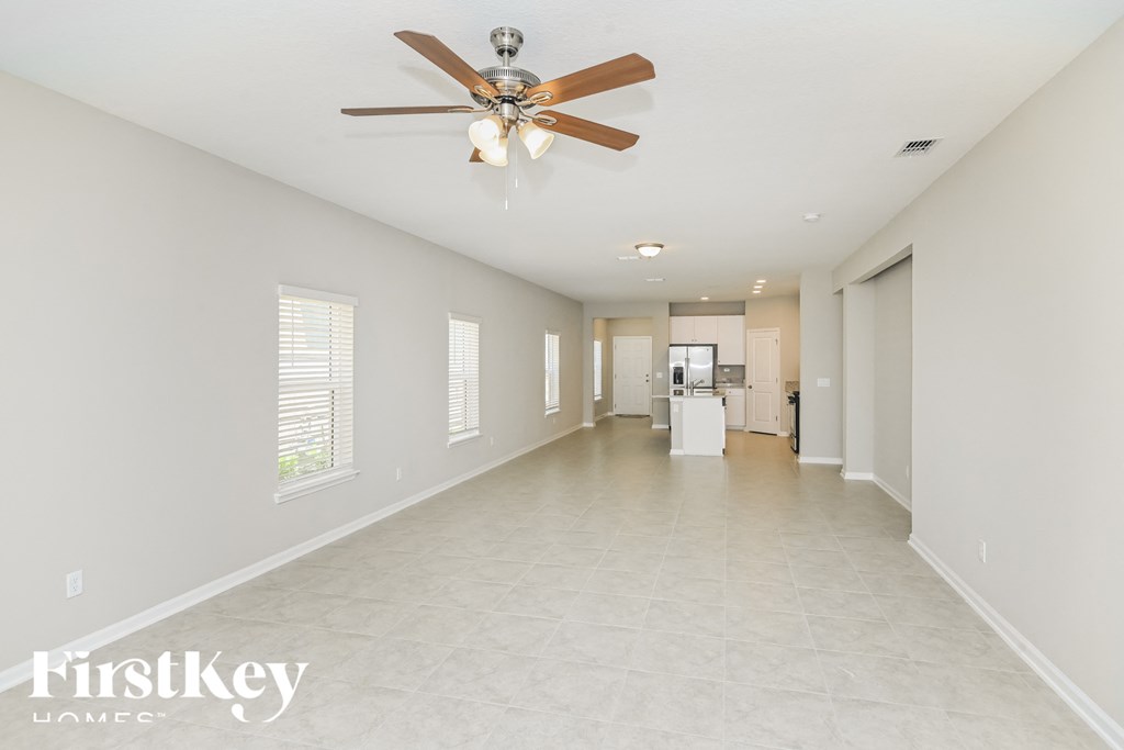 A spacious room with a ceiling fan and tiled flooring.