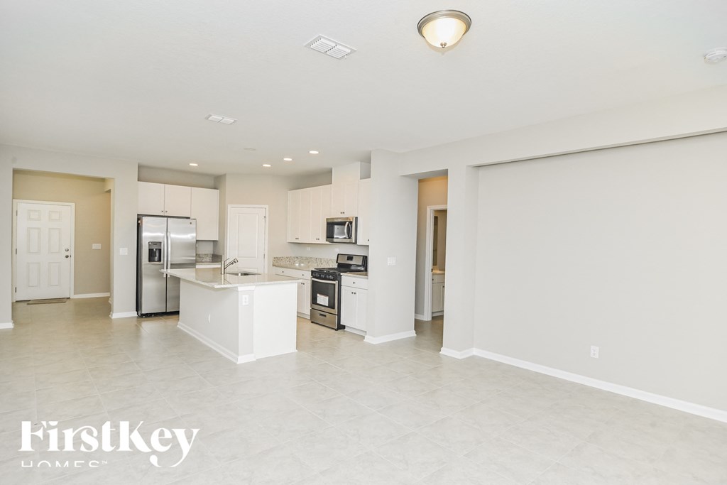 A spacious kitchen with white appliances and a large island.