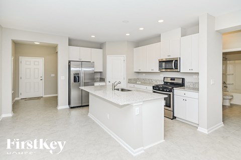 A kitchen with white cabinets and appliances in a modern home.