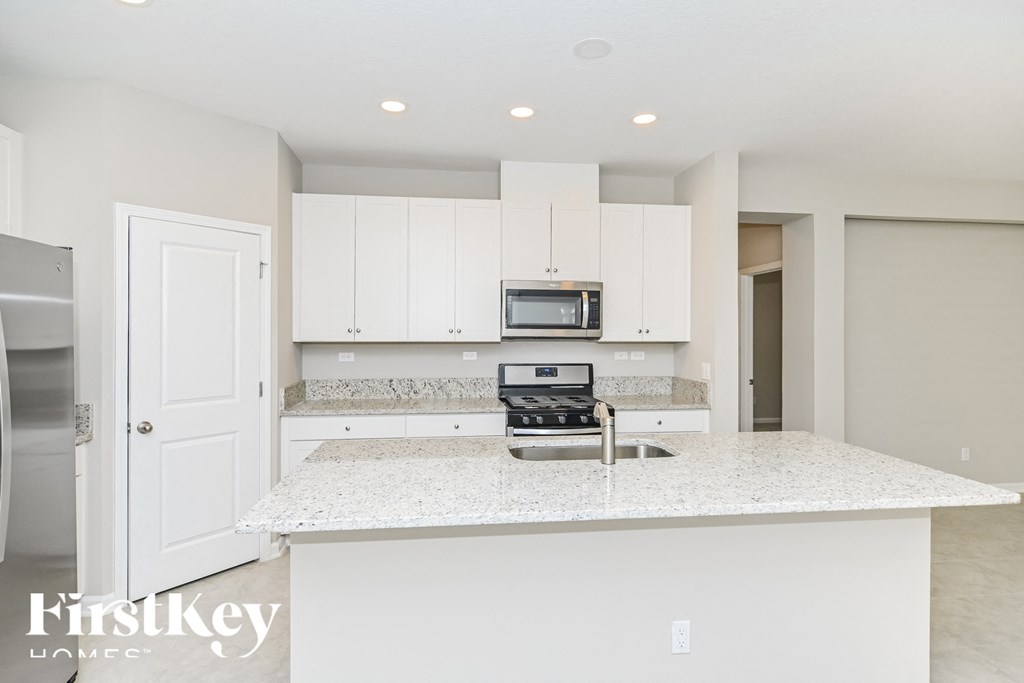 A kitchen with a white countertop and cabinets.
