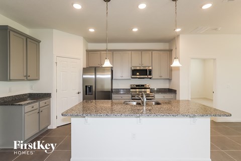 a white kitchen with granite counter tops and stainless steel appliances
