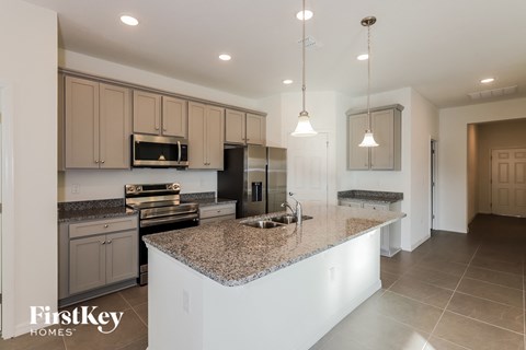 a large kitchen with granite counter tops and stainless steel appliances