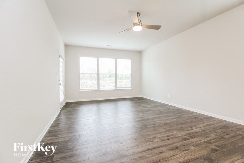 an empty living room with wood floors and a window