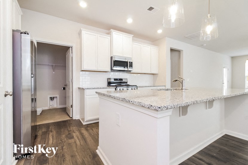 a white kitchen with a marble counter top