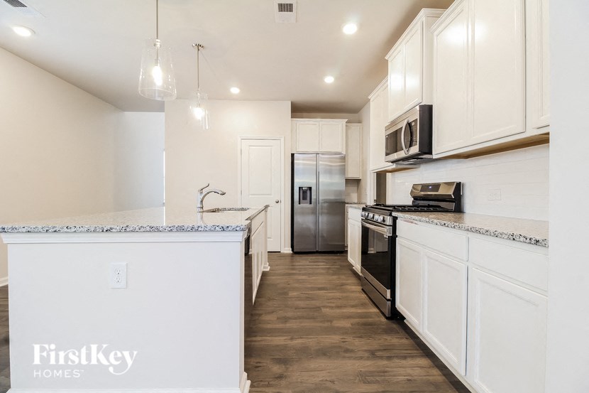 a kitchen with white cabinets and stainless steel appliances