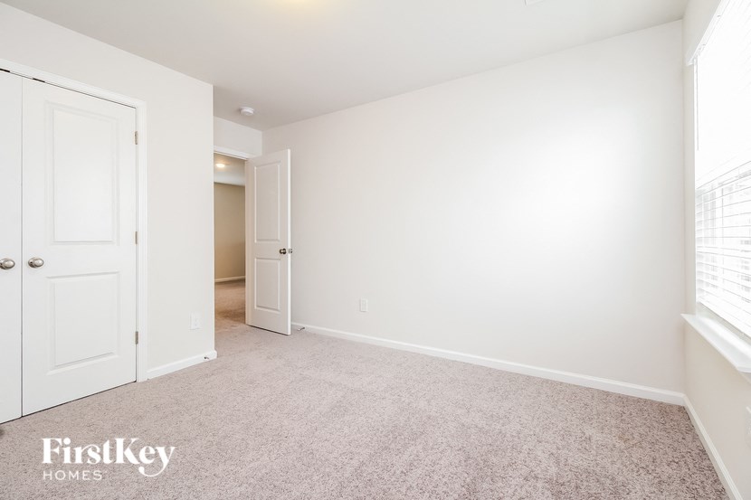 a bedroom with a white door and a carpeted floor