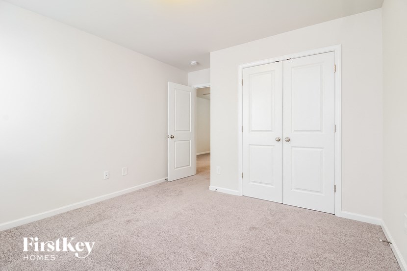 a bedroom with two closets and a carpeted floor