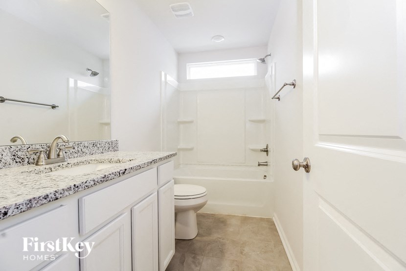 a bathroom with a toilet and a shower and a sink