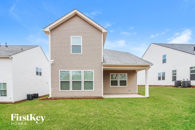 a house with a lawn and two houses behind it