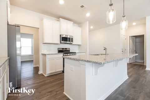 A kitchen with white cabinets and a granite countertop.