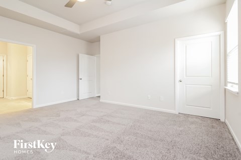a bedroom with a carpeted floor and white doors
