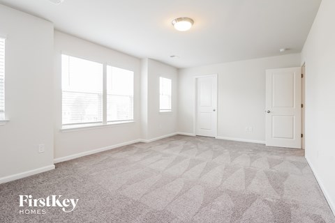 a spacious living room with a carpeted floor and white walls