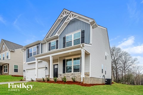 A modern house with a grey and white exterior and a large front porch.