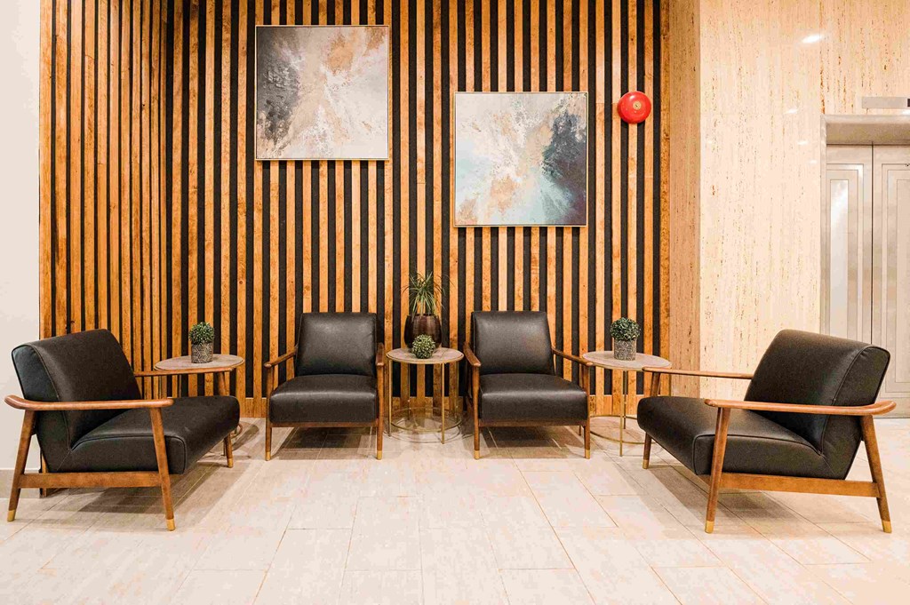 a lobby with chairs and tables and a striped wall