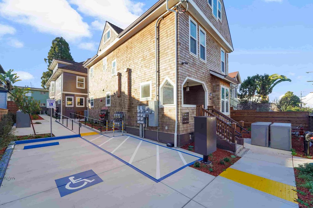a basketball court in front of a house with a handicapped accessible ramp