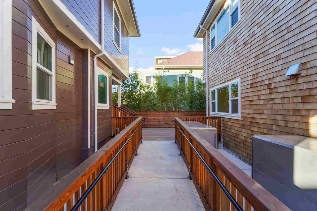 a patio with a wooden fence next to a house