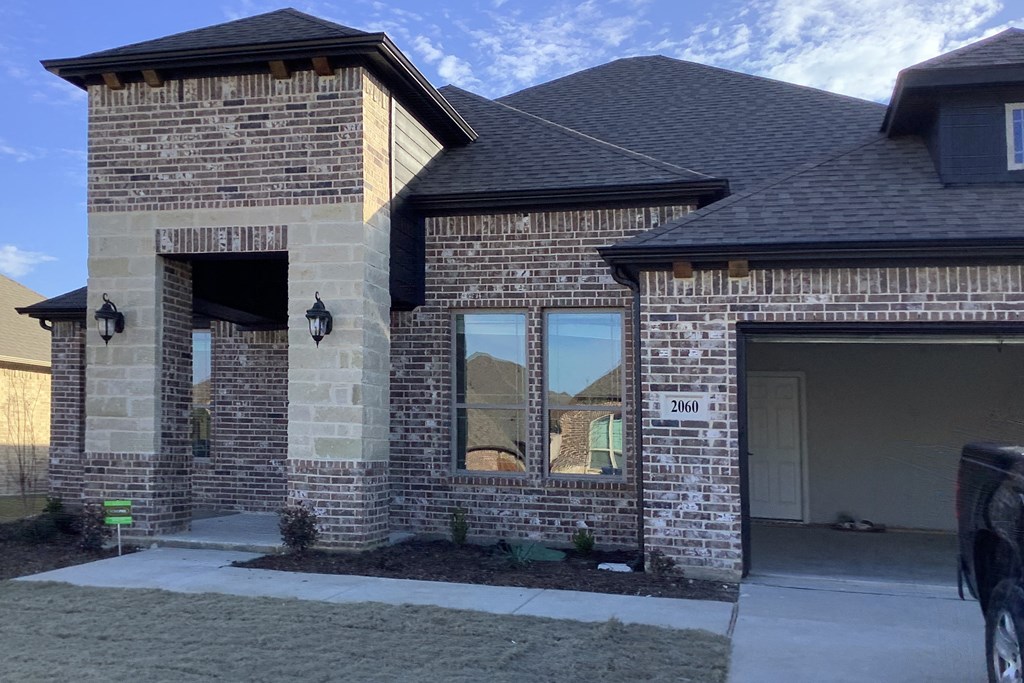 the front of a brick house with a garage door