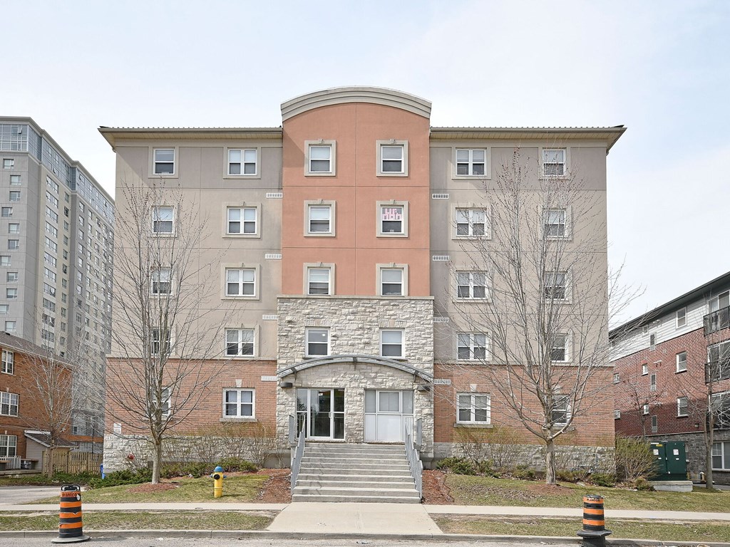 A large building with a red brick section in the middle and a white door in front.
