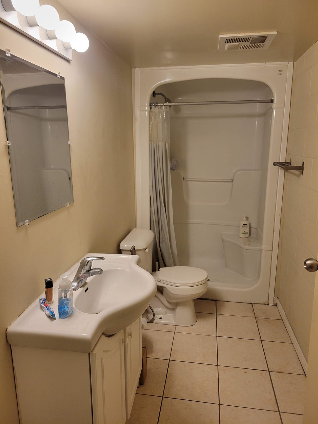 A bathroom with a sink, toilet, and shower.