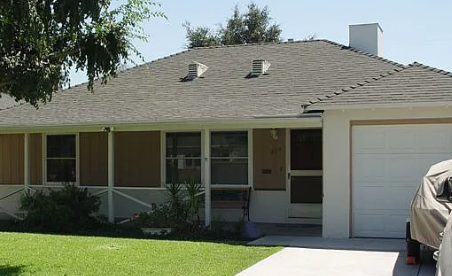 a house with a gray roof and white garage doors