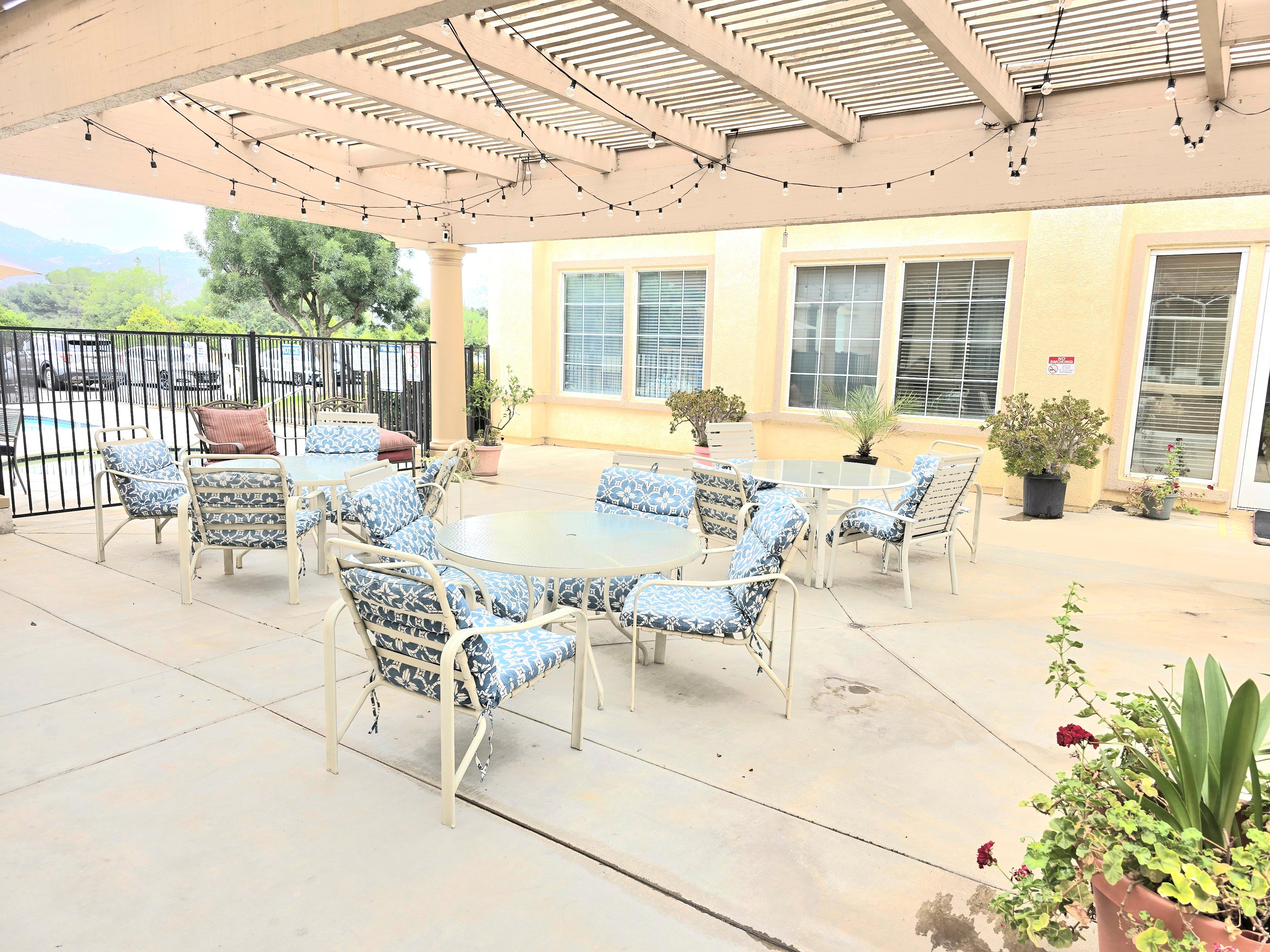 A patio with a table and chairs under a roof.