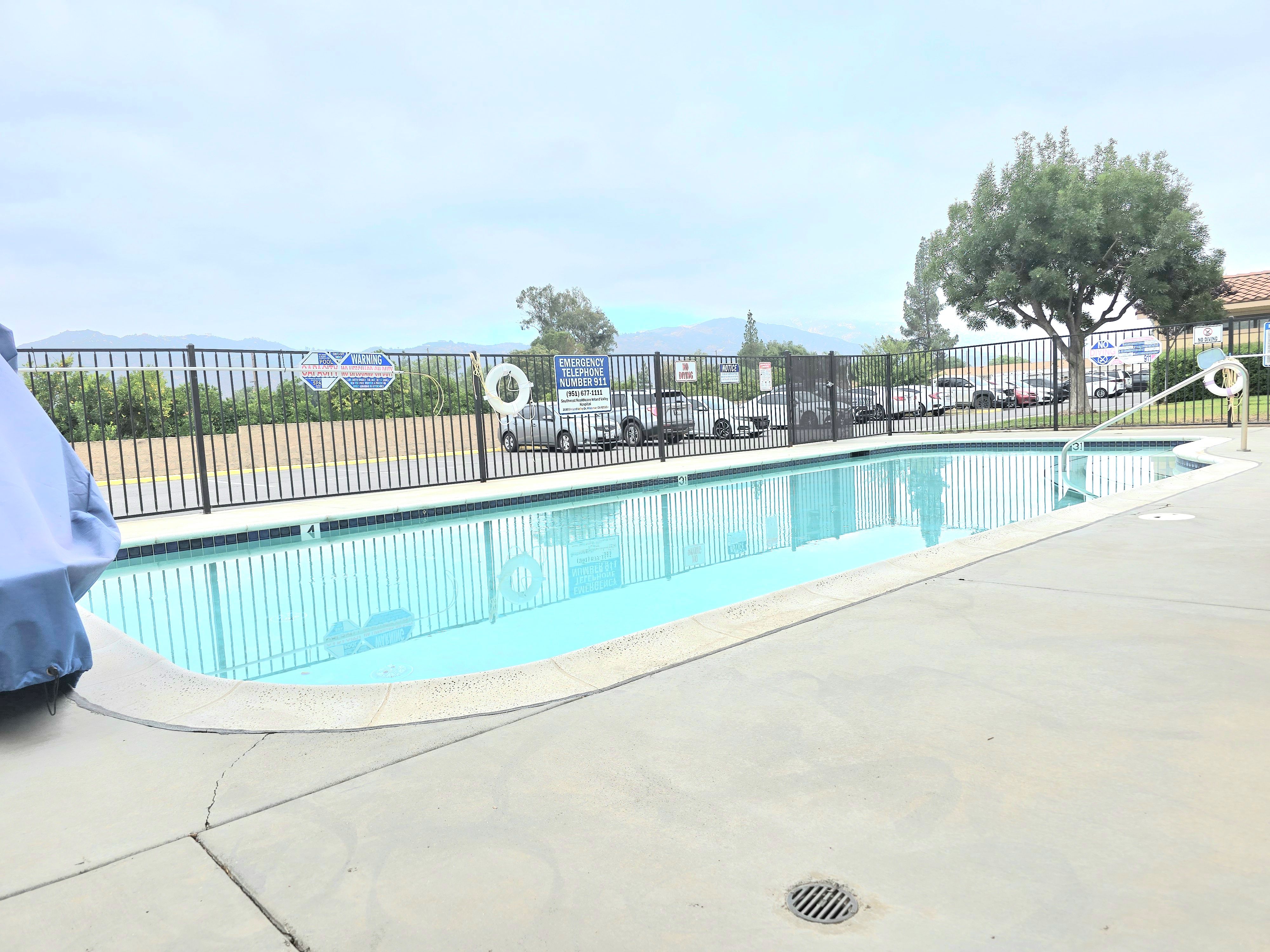 A person in a blue shirt is sitting by a pool.