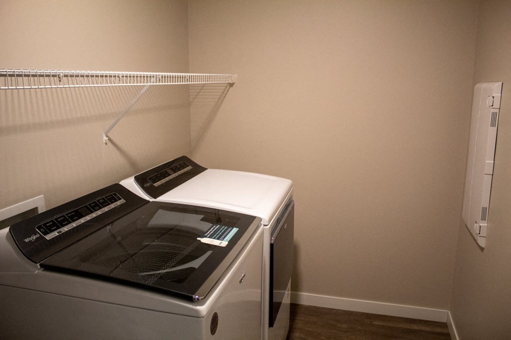 a washer and dryer in a room with a shelf on the wall