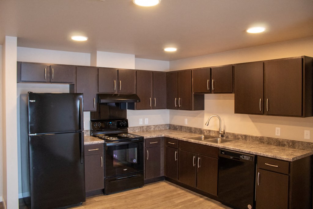 a kitchen with black appliances and granite counter tops