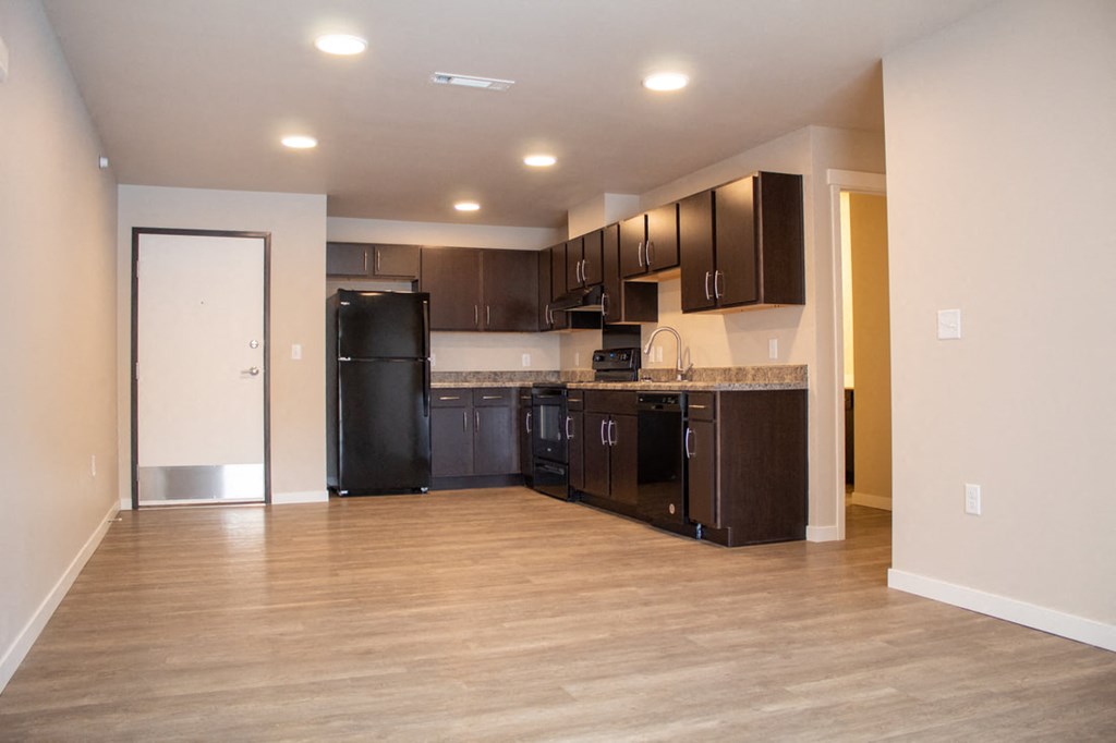 a kitchen with black appliances and dark wood cabinets