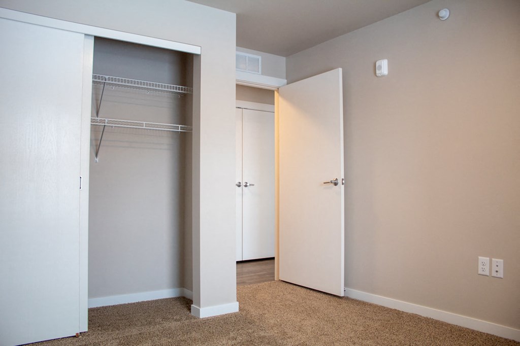a bedroom with a closet and an open closet door