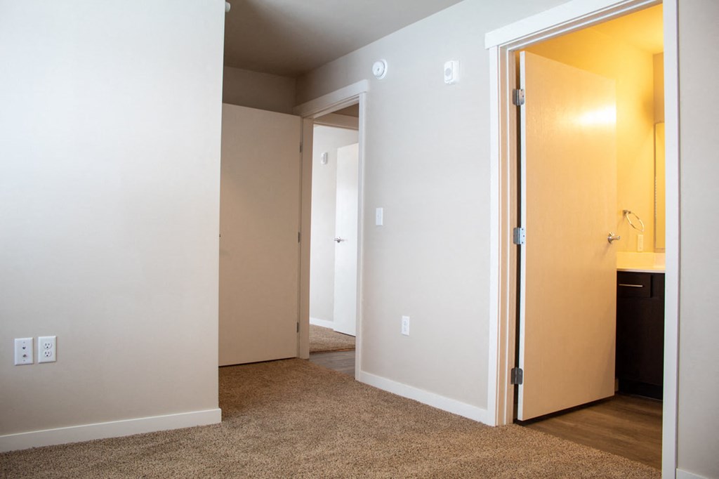 a bedroom with a door to a bathroom and a closet