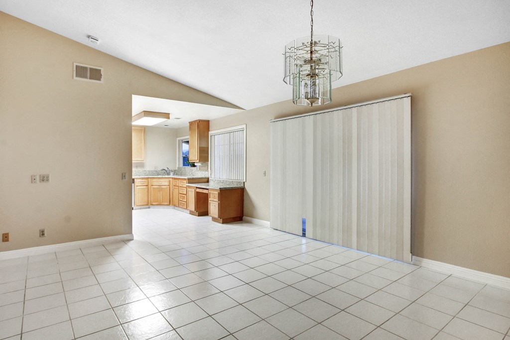 A large empty room with a chandelier hanging from the ceiling.