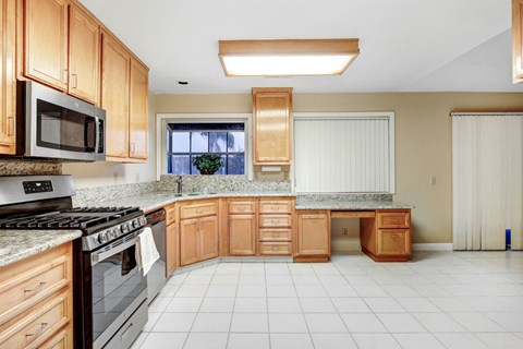 A kitchen with wooden cabinets and a black stove top oven.