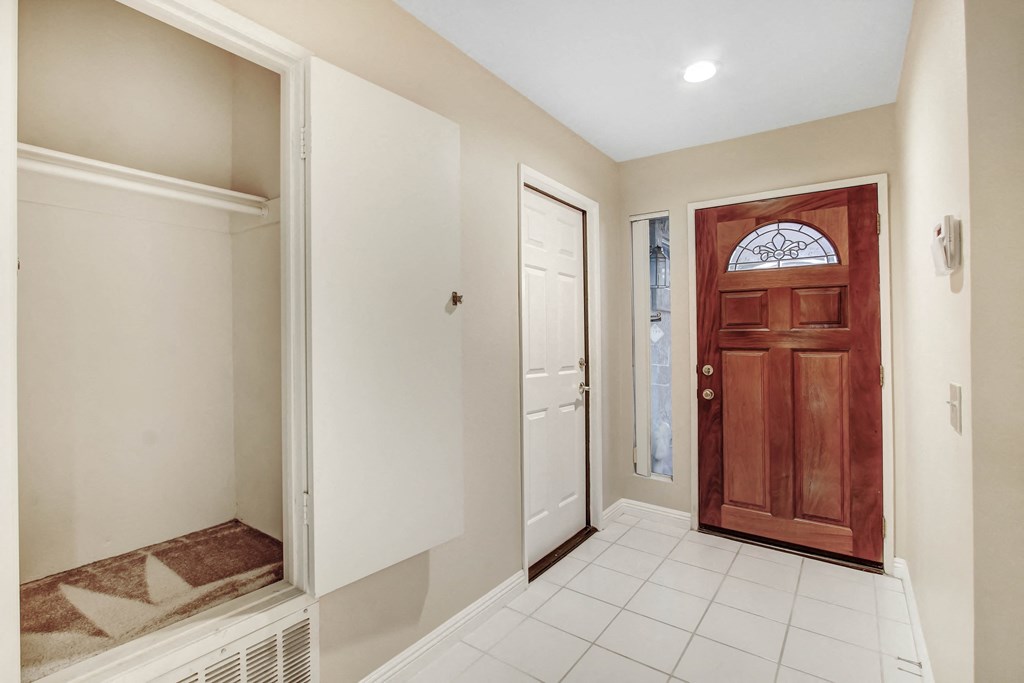 A room with a brown door and a white wall.