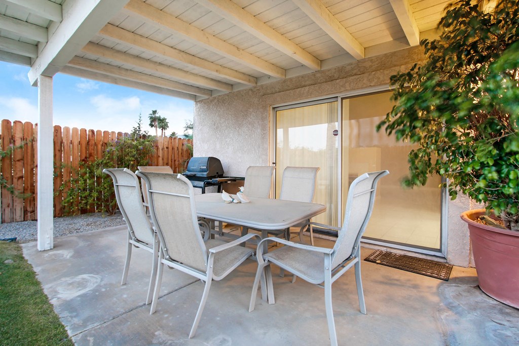 A patio with a table and chairs.