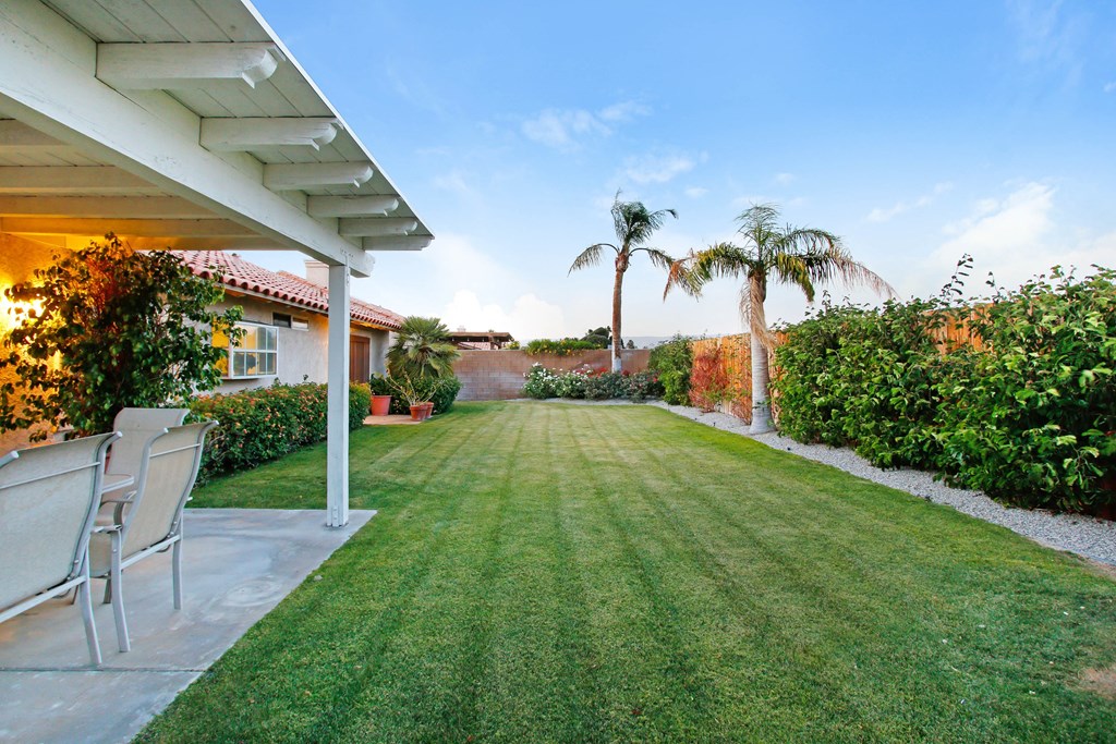 A backyard with a lawn and a patio.