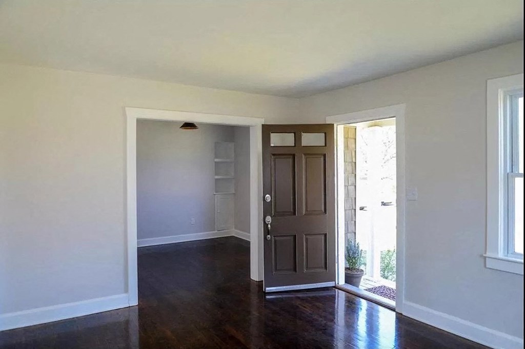 an empty room with a wooden floor and a door