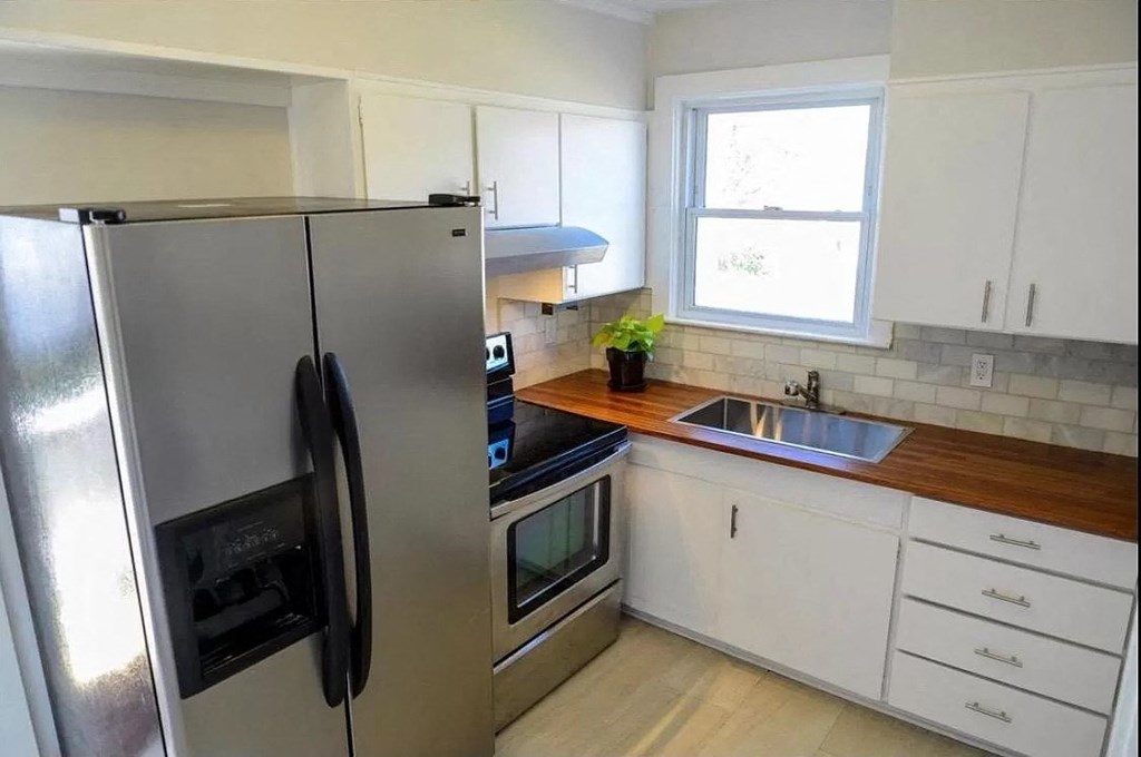 a kitchen with a stainless steel refrigerator and a sink