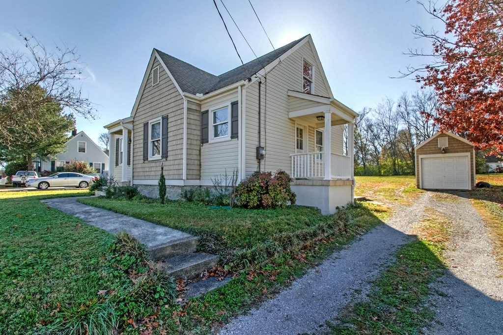 a house with a gravel driveway and a yard with a sidewalk