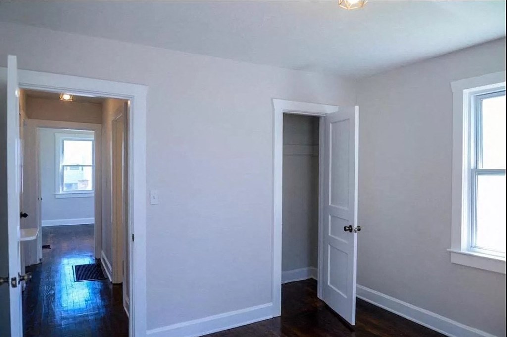 an empty room with white walls and a door to a closet