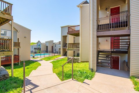 Apartment complex with a pool and a walkway.
