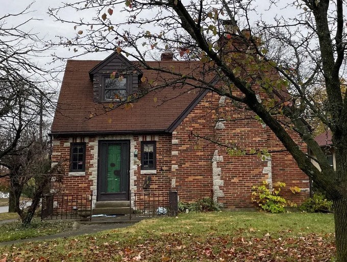 a small brick house with a green door