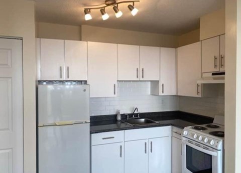 A kitchen with white appliances and cabinets.