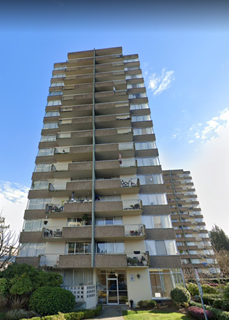 a tall apartment building with balconies in front of a blue sky