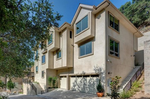 A modern house with a beige exterior and large windows.