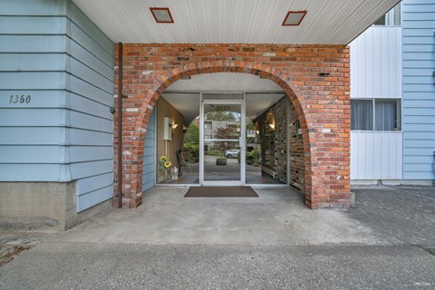 A blue house with a brick archway entrance.