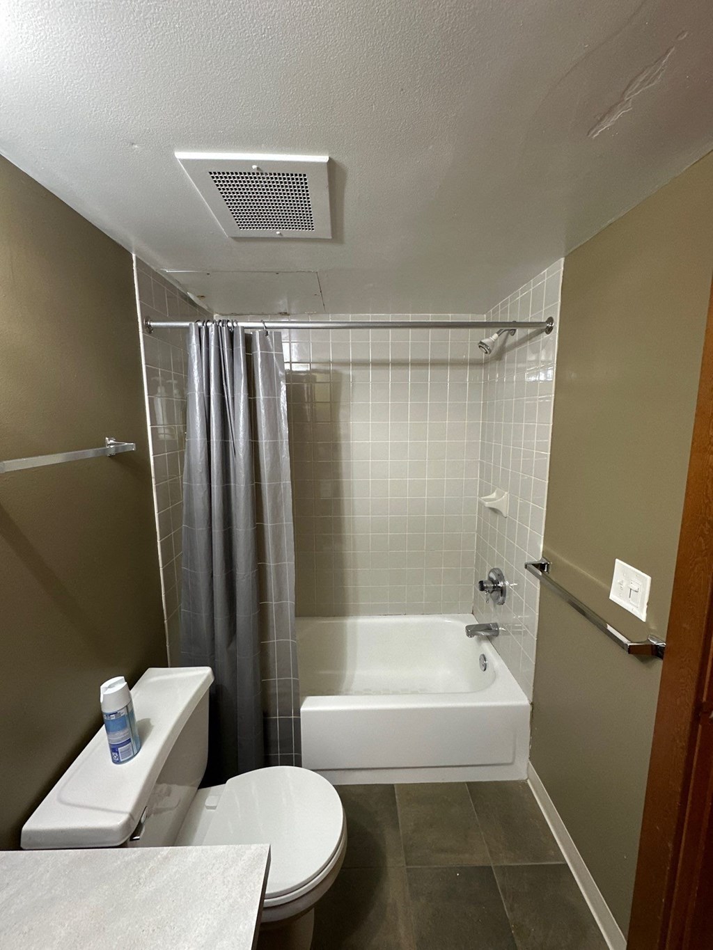 a bathroom with a toilet and a tub and a shower