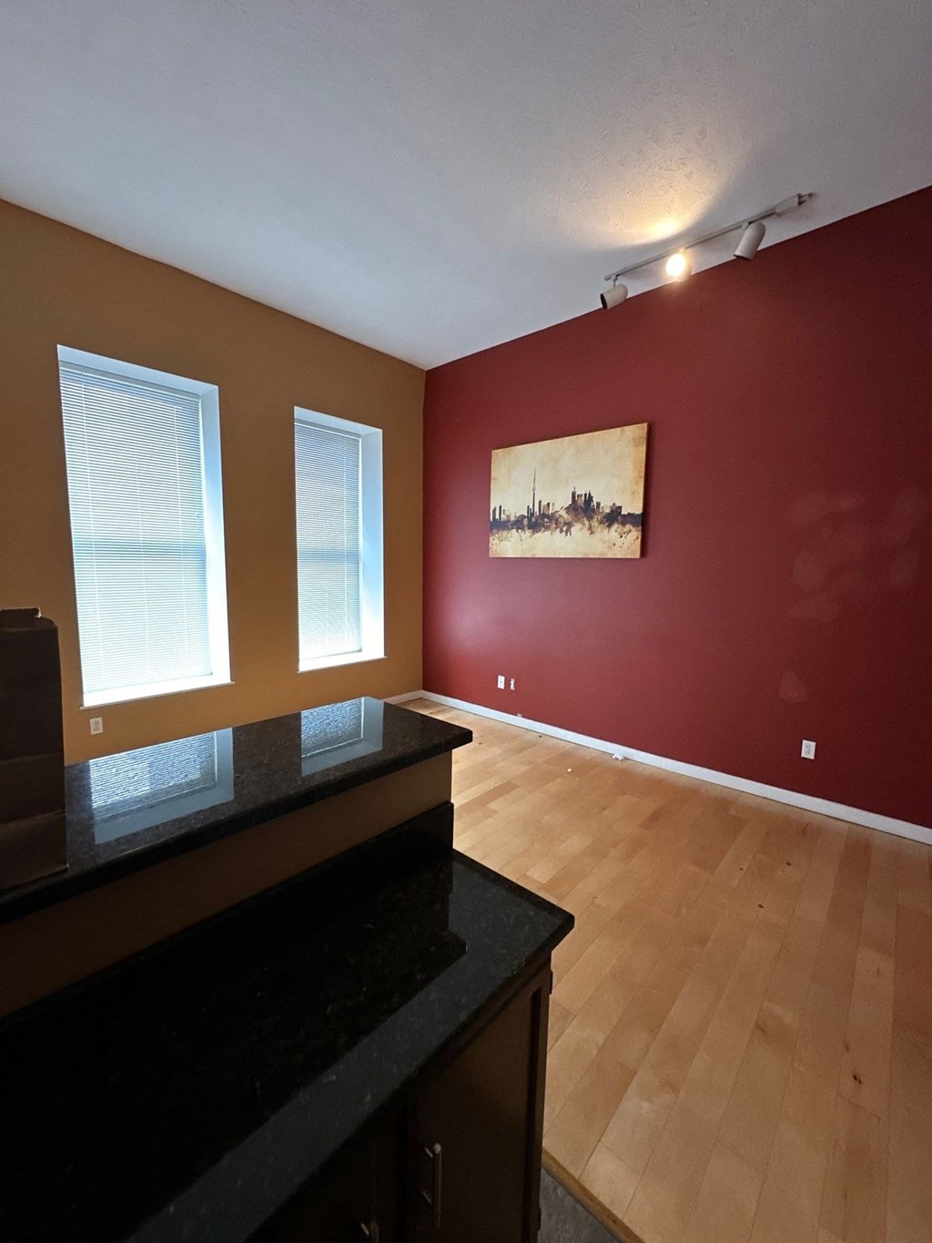 an empty living room with red walls and a wood floor
