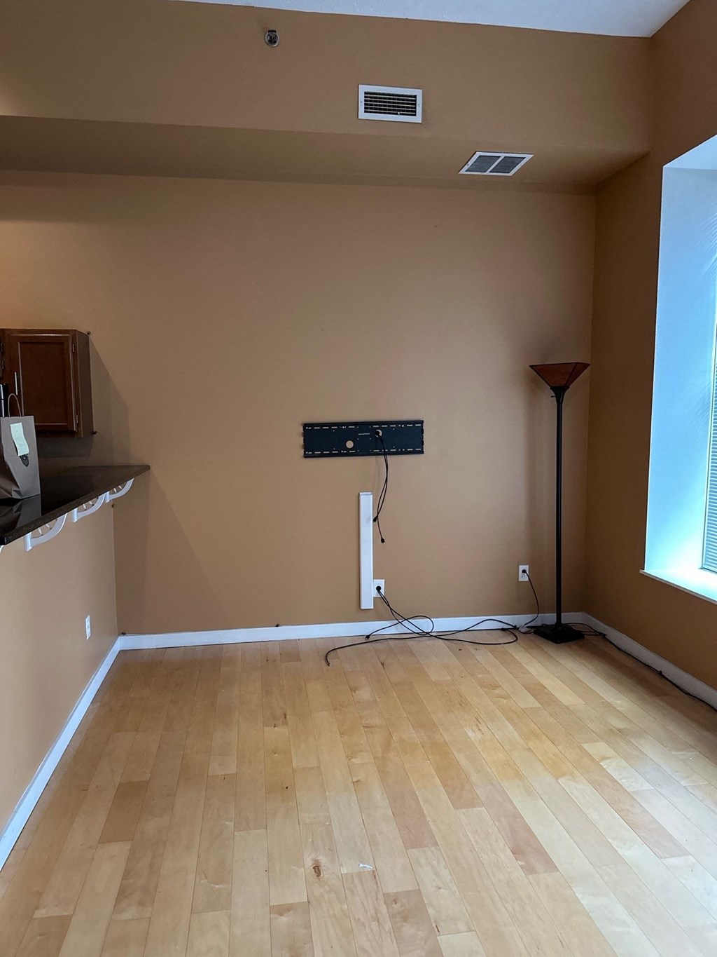 an empty room with a wood floor and an air conditioner