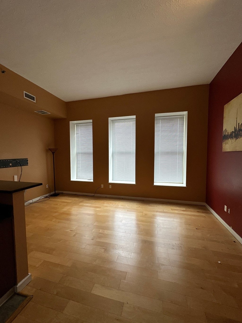 an empty living room with red walls and a wood floor